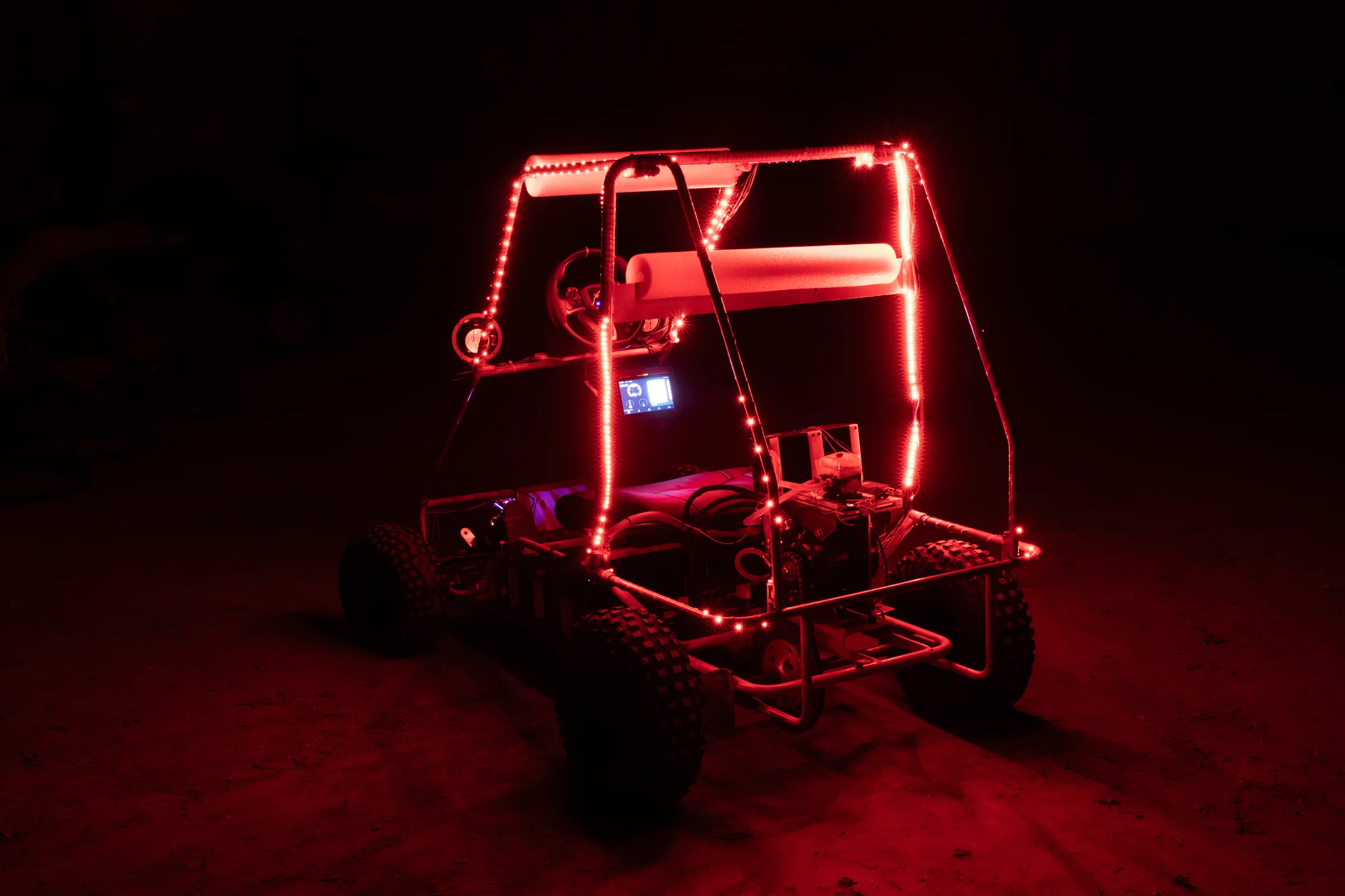 The kart at night, its frame lit red by LED strips
